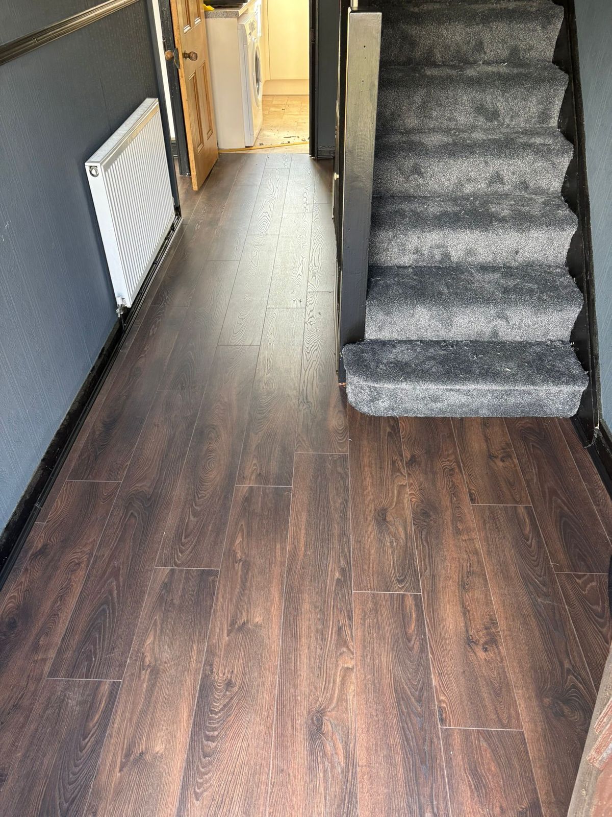 Dark laminate hallway with grey stair carpet