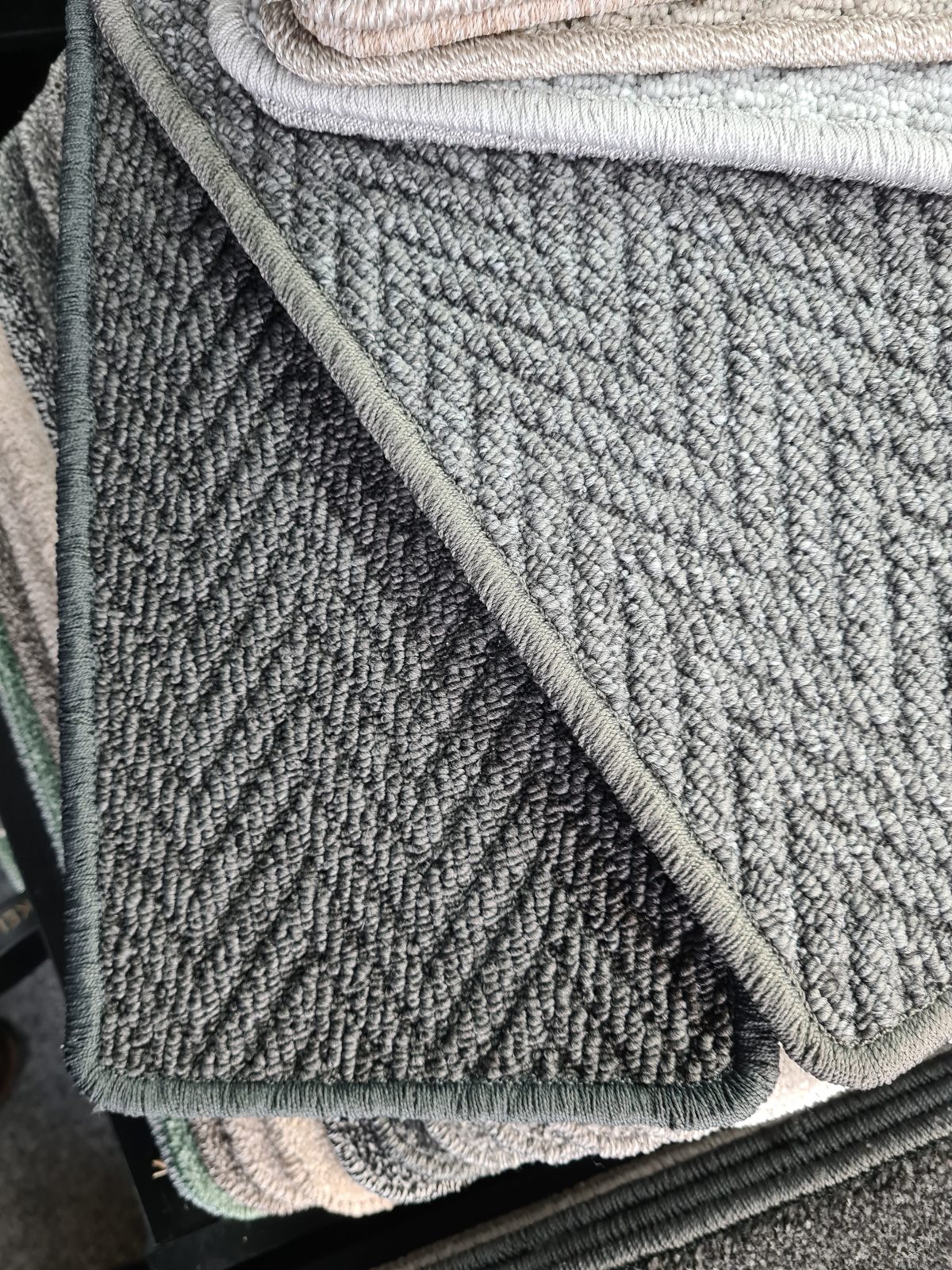 Stack of grey herringbone-weave carpet samples