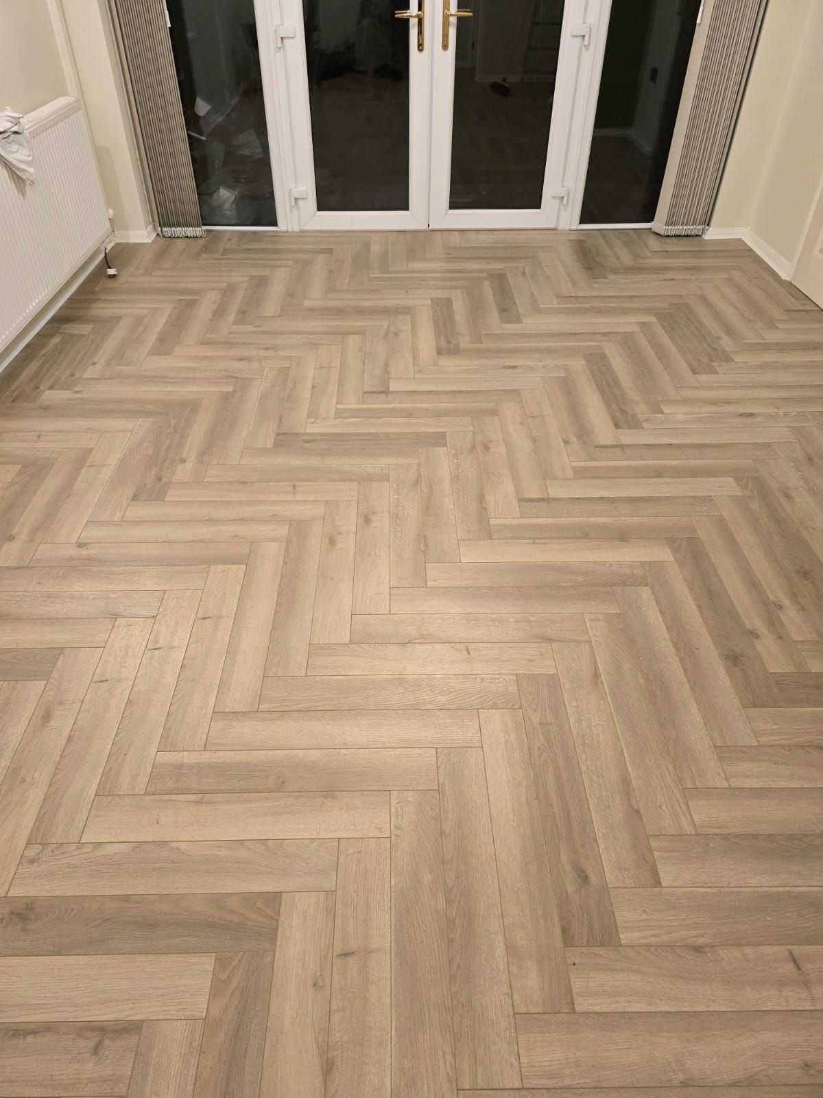 Pale grey herringbone floor by french doors