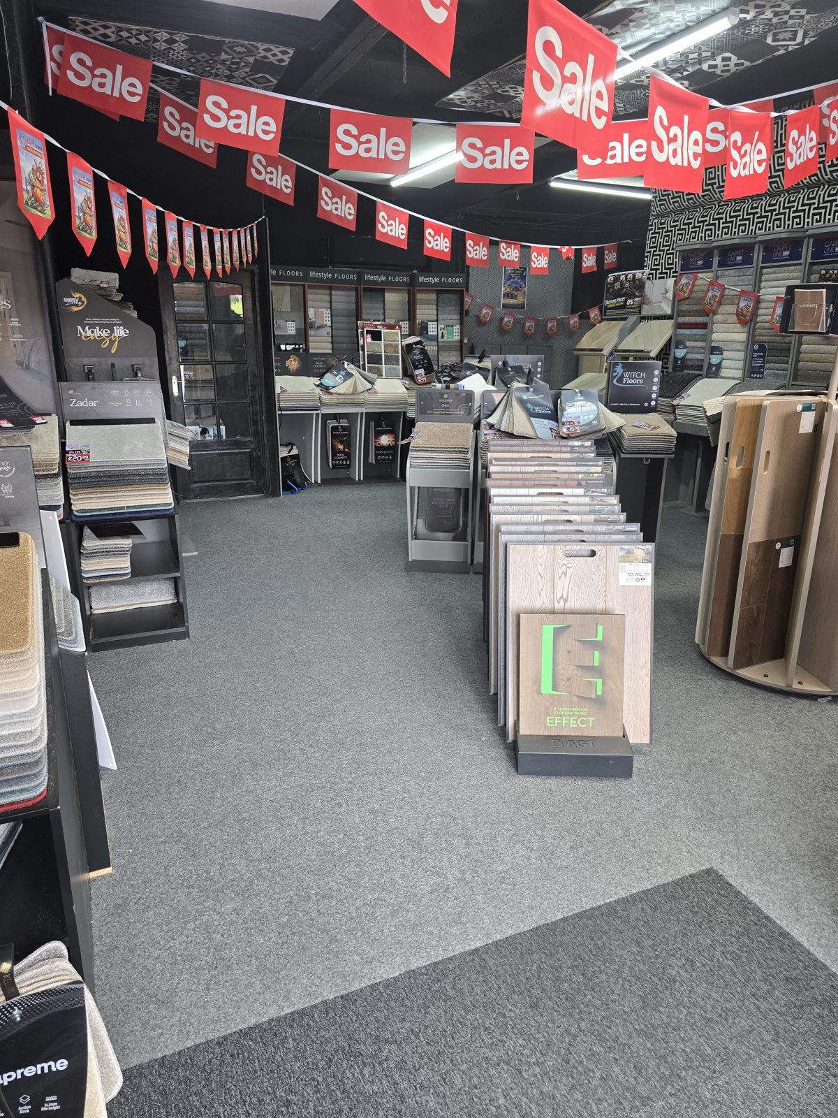 Inside the Love Carpets showroom with sample stands and sale offers